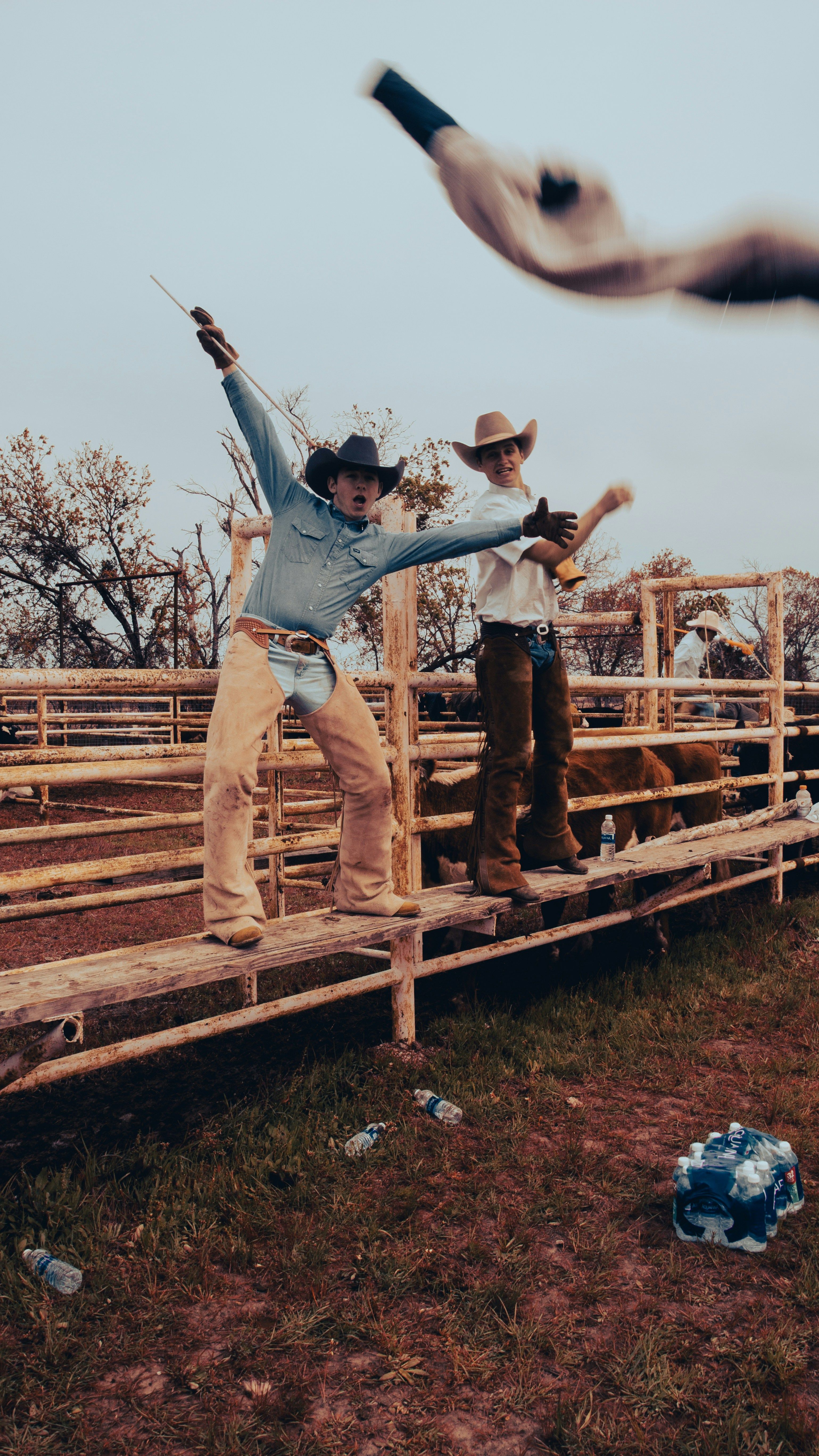 Dynamic kick pose at a wooden ranch fence