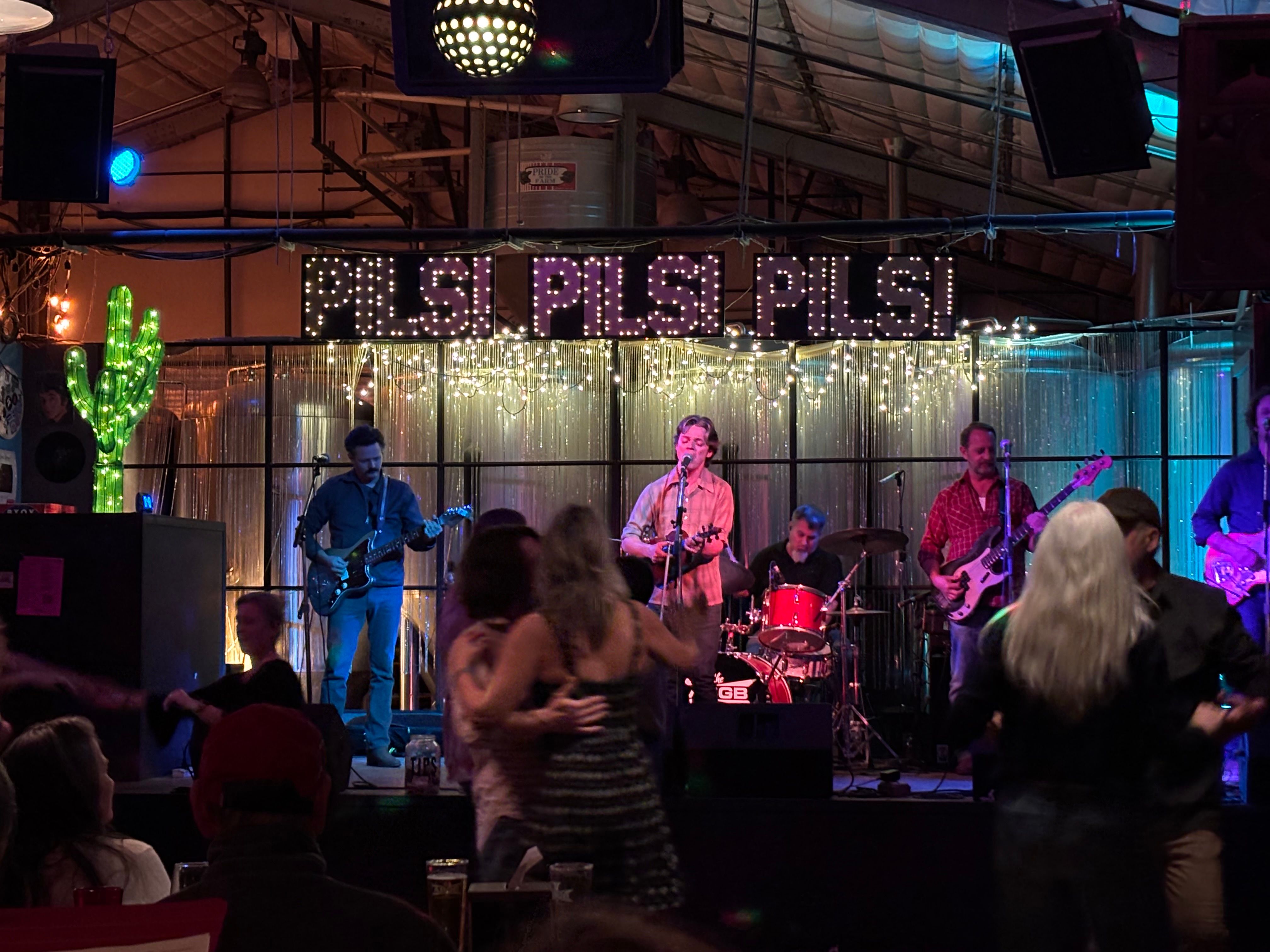 String lights over a dance floor at a barn venue